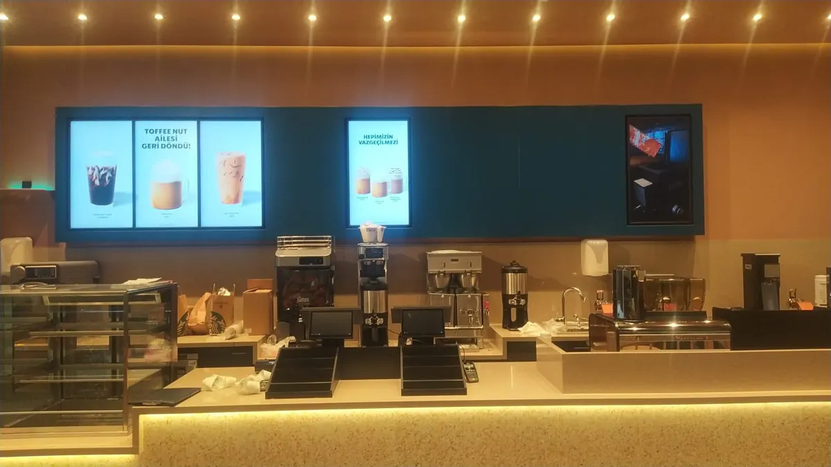 Kafe kasa arkasında dijital menü ekranları